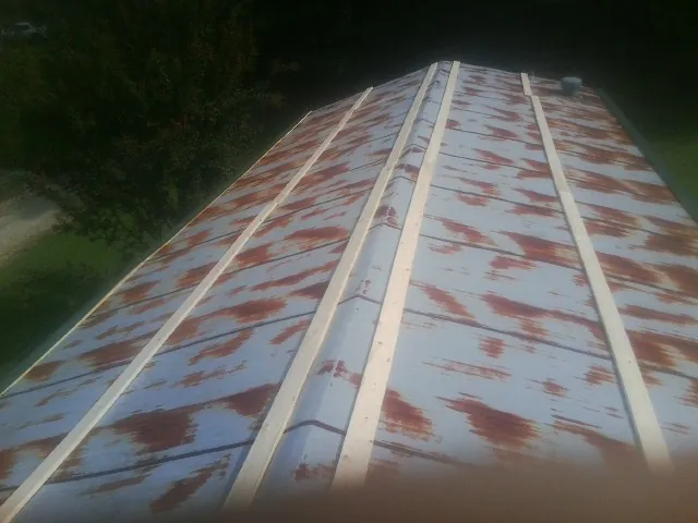 Rusted metal roof panels with new wood purlins before replacement — Storm Damage Roof Repair in Rocky Mount by Roofing Brothers
