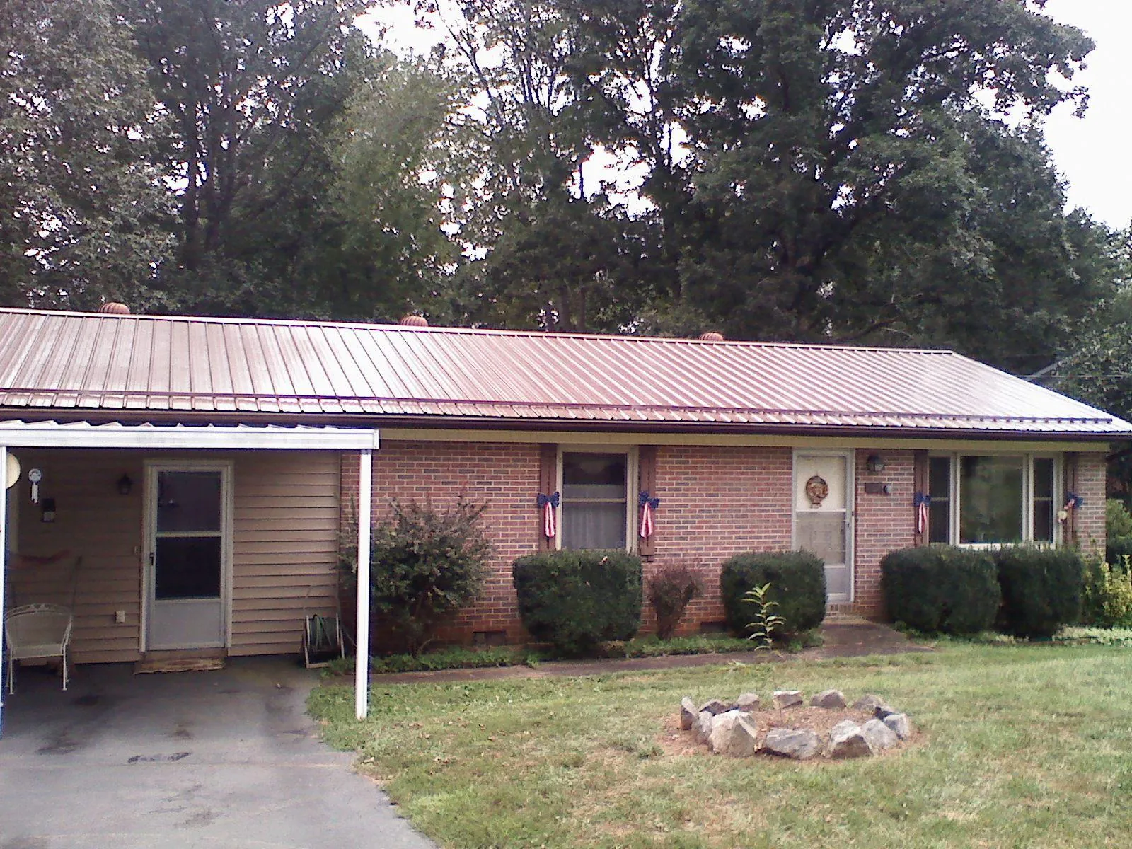 Bronze metal roof and carport on a brick ranch home — Roof Repair work by our crew in Rocky Mount